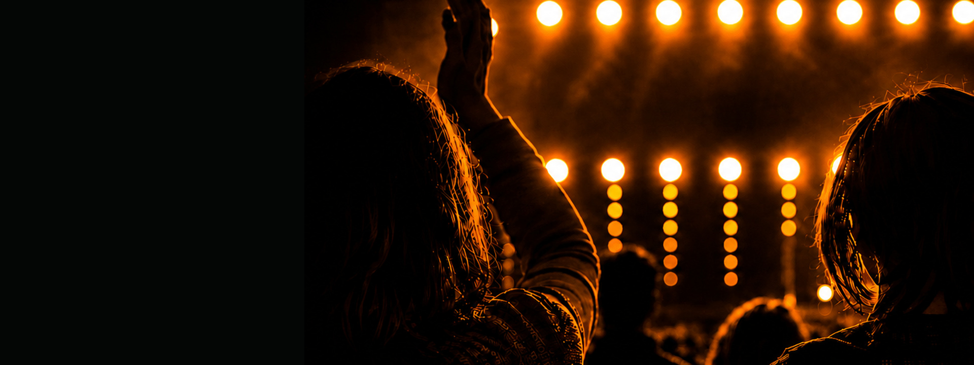 Audience watching a live performance under amber stage lighting